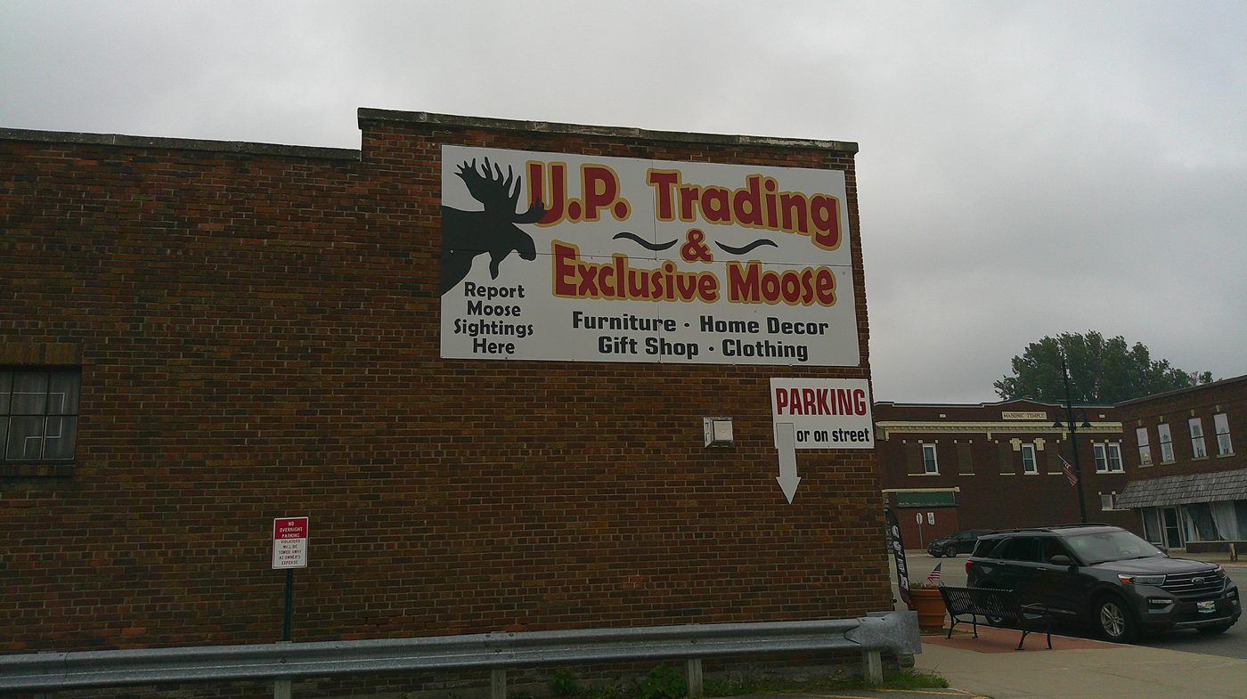 U.P. Trading and Exclusive Moose storefront sign listing Furniture, Home Decor, Gift Shop, and Clothing